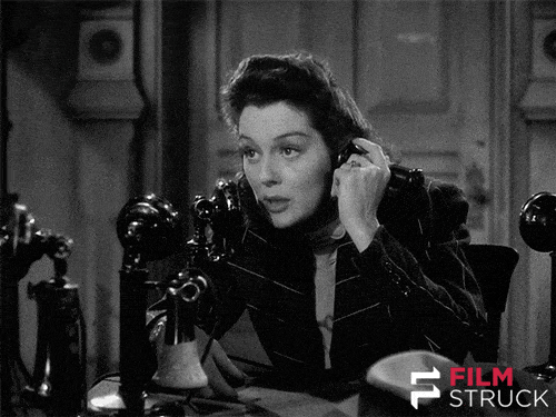 Woman speaking on old telephone in black and white
