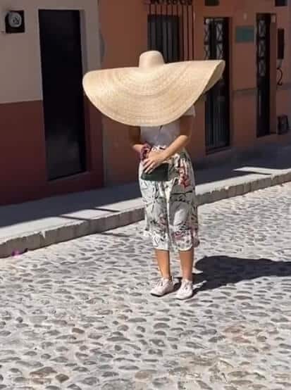 Elise wearing a huge hat in the wind covering her entire face and neck.